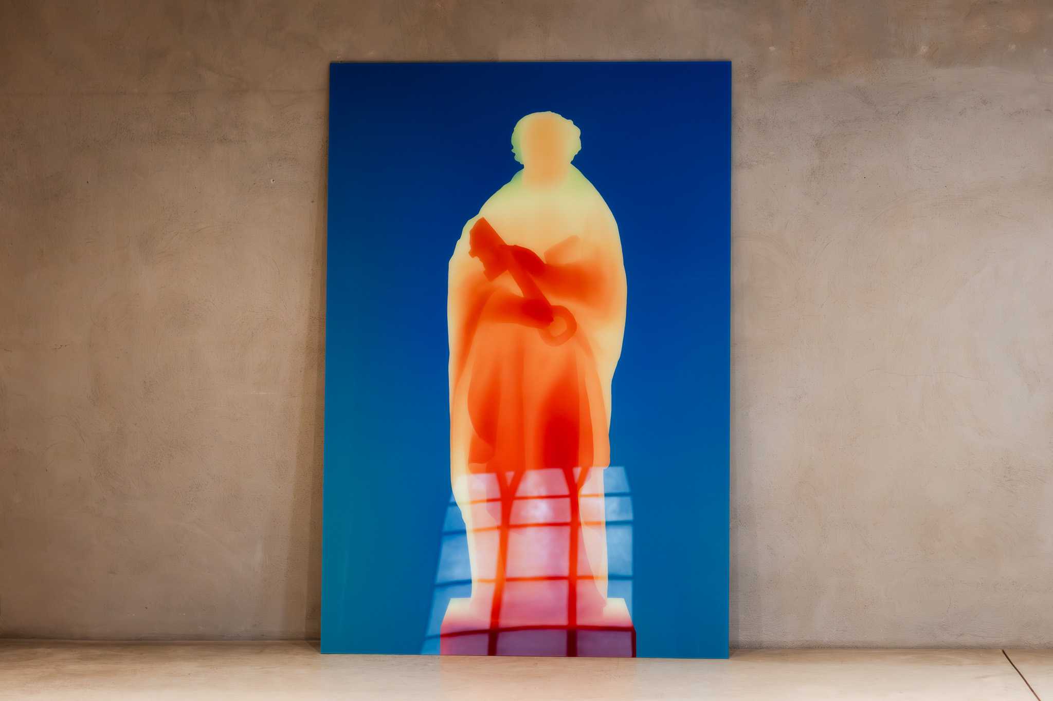 A large print leaning against a plaster wall: Saint Peter holding his key, rendered in the orange-to-blue colours of a depth map.