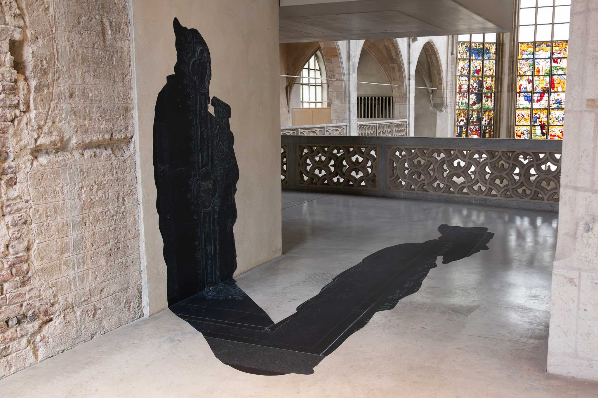 Wider view: the prophet on the pier at left, its shadow running out across the floor with the ornament and script of the oath book illumination worked into it.