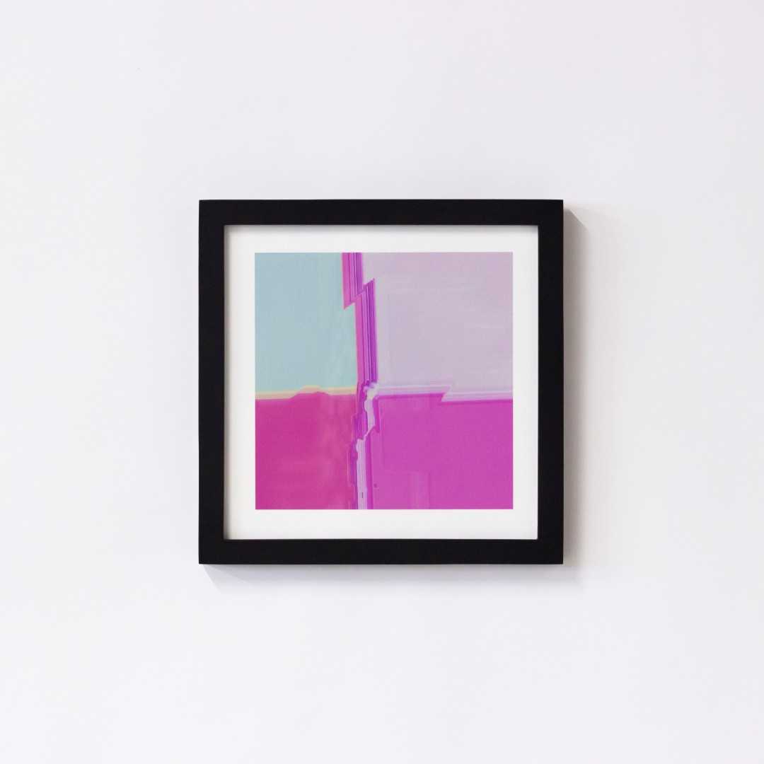 A print of an abstract pink texture in a black frame